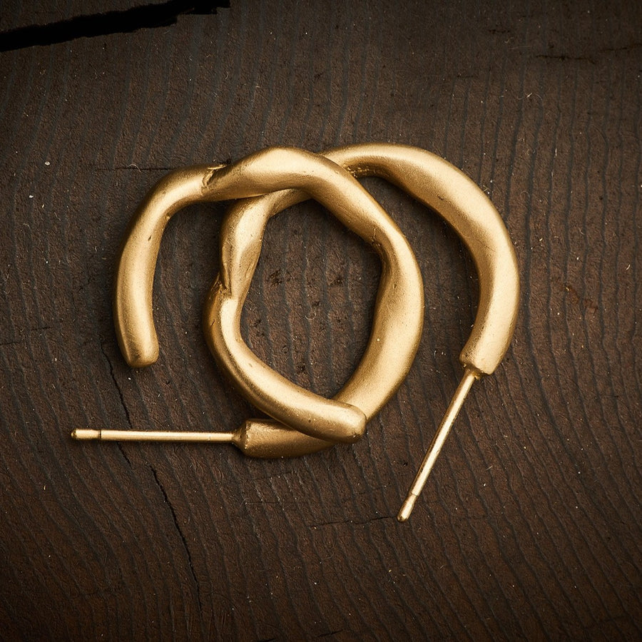 Small heavy gold hoops with an organic twist